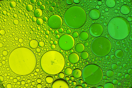Oil drops in water on a coloured backgroundの写真素材
