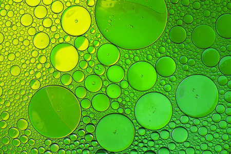 Oil drops in water on a coloured backgroundの写真素材