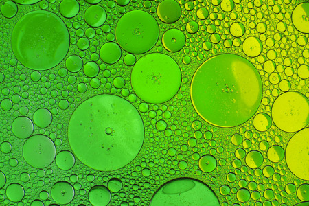 Oil drops in water on a coloured backgroundの写真素材