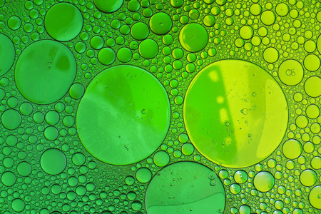 Oil drops in water on a coloured backgroundの写真素材