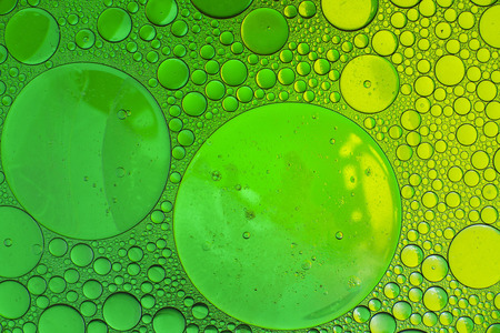 Oil drops in water on a coloured backgroundの写真素材