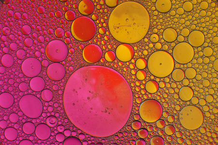 Oil drops in water on a coloured backgroundの写真素材