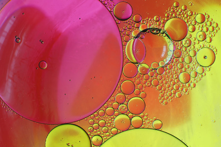 Oil drops in water on a coloured backgroundの写真素材
