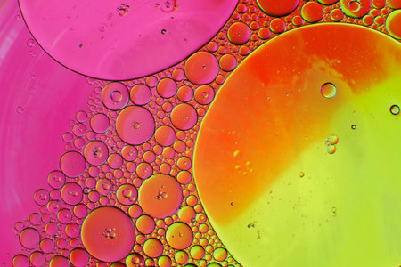 Oil drops in water on a coloured background