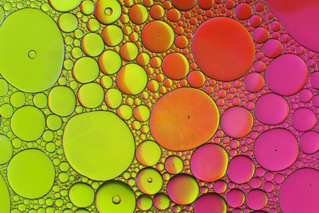 Oil drops in water on a coloured backgroundの写真素材