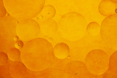 Oil drops in water on a coloured backgroundの写真素材