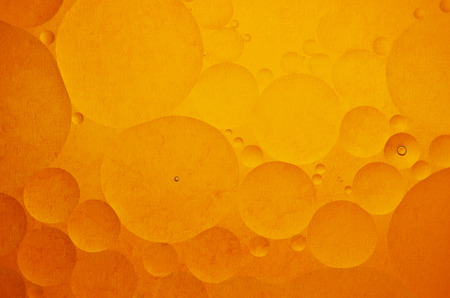 Oil drops in water on a coloured backgroundの写真素材