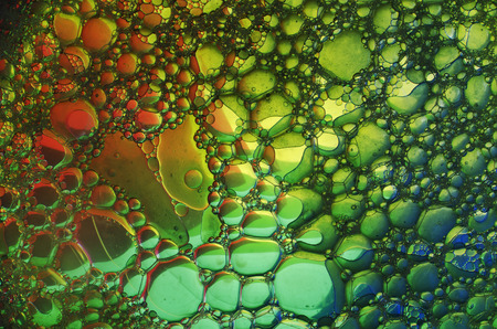 Oil drops in water on a coloured backgroundの写真素材