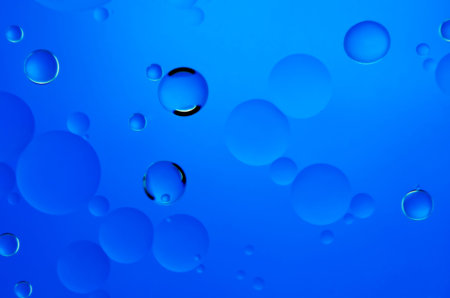 Oil drops in water on a coloured background