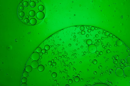 Oil drops in water on a coloured background