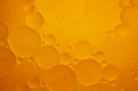 Oil drops in water on a coloured backgroundの写真素材