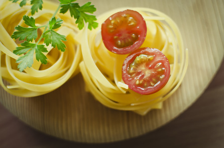 Raw pasta on the wooden table.の写真素材