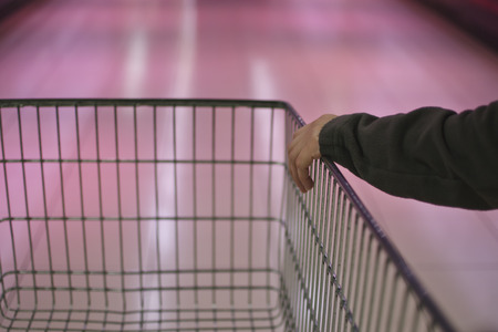 Supermarket interior, empty shopping cart.の写真素材