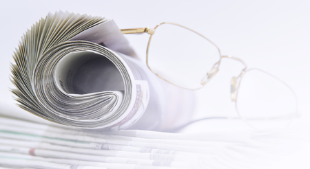 Rolls of newspapers with glassesの写真素材