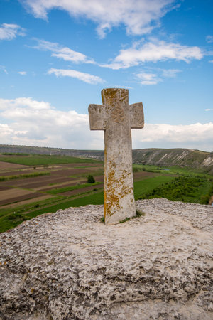 Old stone cross. Ancient christian place Orhei, Moldova Republic. Summer hills and fields view .の写真素材
