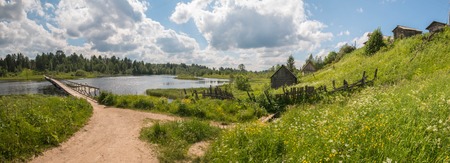 North Russian village. Summer day, river, old cottages on coast.の写真素材