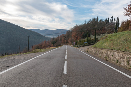 European country road. Turn right, road sign, trees and bright blue sky. Asphalt and dry grassの写真素材