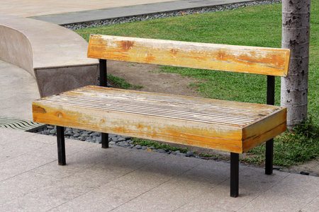 Wooden bench in the park with green grass on the ground.