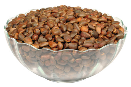 Siberian cedar pine seeds in a glass dish on a white backgroundの写真素材