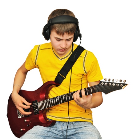 A teenager looks at a string electric guitarの写真素材