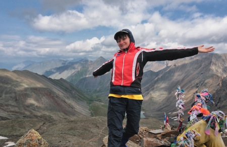 Happy girl on a mountain top. Mountain tourism. The joy of victory and freedomの写真素材