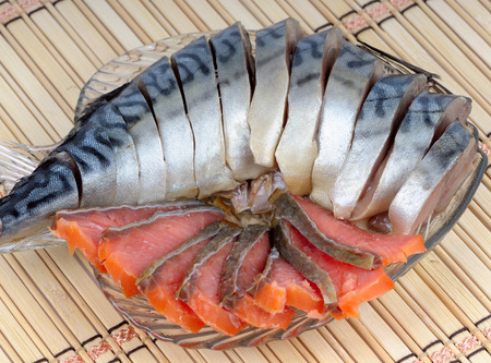 Sliced mackerel and salmon slices in a glass dishの写真素材