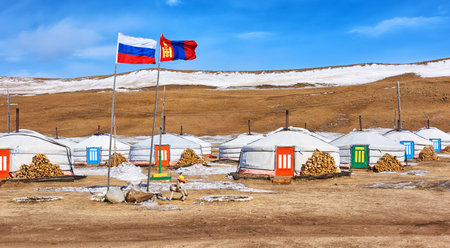 Russian and Mongolian flag next to yurts . Mongolia