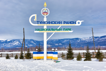 TUNKINSKY DISTRICT ,BURYATIA ,RUSSIA - March,09,2016: Sign at entrance to Tunkinsky District " Tunkinsky District National Park ". Coat of arms of municipality of Tunkinsky district topのeditorial素材
