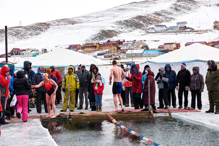 SAHYURTA ,IRKUTSK REGION, RUSSIA - March 11.2017: Cup of Baikal. Winter Swimming. Swimmers came out of water after finish and group of fans at edge of ice holeのeditorial素材