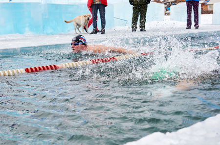 SAHYURTA, IRKUTSK REGION, RUSSIA - March 11.2017: Cup of Baikal. Winter Swimming Competitions. Splashing water from a swimmers dive. Butterflyのeditorial素材