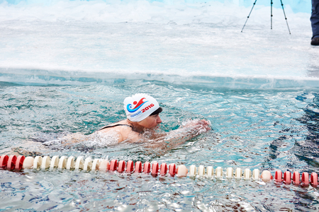 SAHYURTA, IRKUTSK REGION, RUSSIA - March 11.2017: Cup of Baikal. Winter Swimming Competitions. Floating woman in very cold waterのeditorial素材