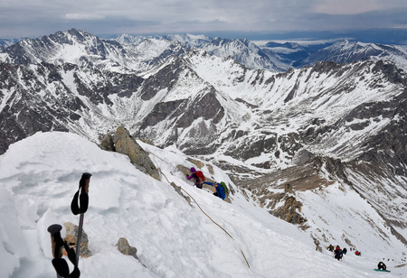 MUNKU-SARDYK, BURYATIA, RUSSIA-April 29,2017: Climbing peak of Munku-Sardyk in background of mountain massif. Mountaineers move around with their hands on ropeのeditorial素材