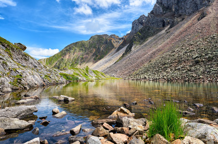 Little shallow lake with clear clear water in Siberian mountains. High mountain tundra. Eastern...