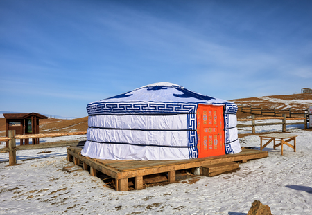 KHUZHIR, IRKUTSK, RUSSIA - March 7, 2017: Buryat yurt is installed on decking floor in steppe by fence. National designs adorn front door and coverのeditorial素材