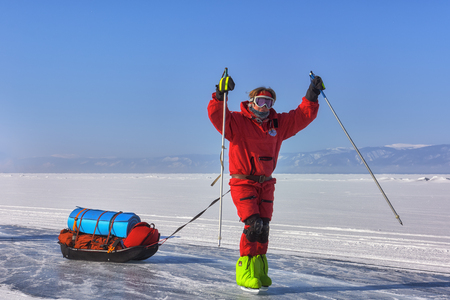 LAKE BAIKAL, IRKUTSK REGION, RUSSIA - March 08, 2017: Welcome speech of participant of polar expedition. One woman on skates with sledge drag on ice of frozen lakeのeditorial素材