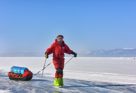 LAKE BAIKAL, IRKUTSK REGION, RUSSIA - March 08, 2017: One woman on skates. A polar explorer in orange overallのeditorial素材
