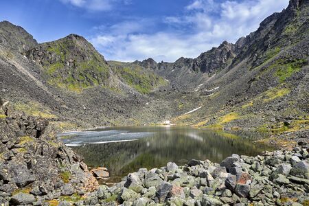 Lake at bottom of mountain depression formed during ice age. Poor vegetation in the harsh climatic zone of the highlands complements the landscapeの写真素材