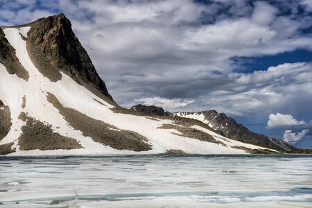 Glacier on mountain and lake with floating ice on surface. Eastern Sayan. Tuva. Central Asiaの写真素材