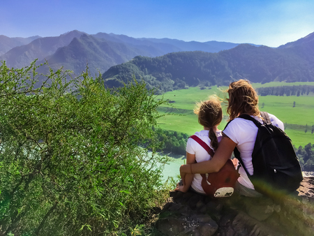 Woman and child looking into the distance to the mountains, the river, traveling with family in the mountainsの写真素材