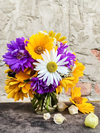 A bouquet of flowers on the background of the old brick walls and plasterの写真素材