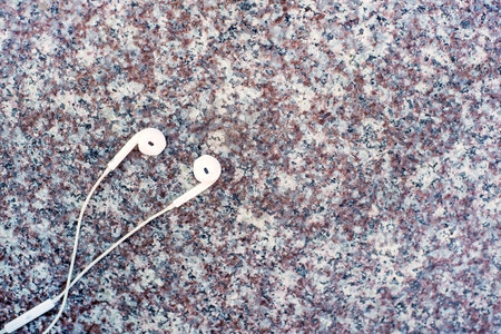 White headphones lying on the marble