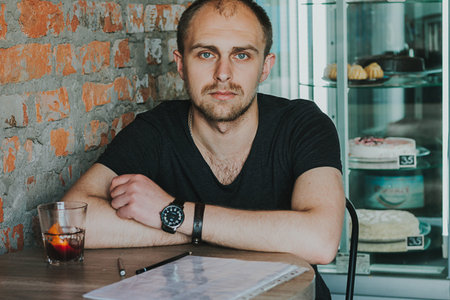 Gorgeous man. Vertical portrait of a handsome young elegant man in a suit having a drink