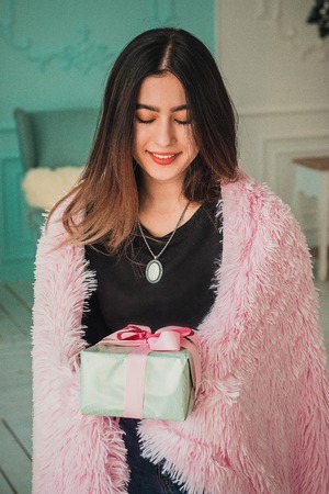 Christmas girl x-mas gift boxes new year, winter december, Smiling happy girl with gift box at decorated furtree, christmas interior and new year decorationの写真素材
