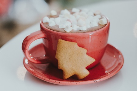 A cocoa drink in a clay mug on a shabby wooden background. A porcelain cup of black coffee with white marshmallows.の写真素材