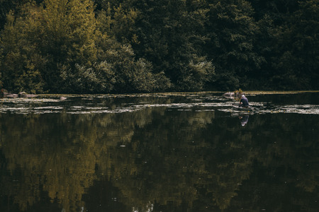 Young fisherman in a boatの写真素材