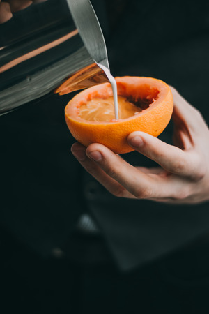 Conceptual Coffee latte art making in a grapefruit cup by baristaの写真素材
