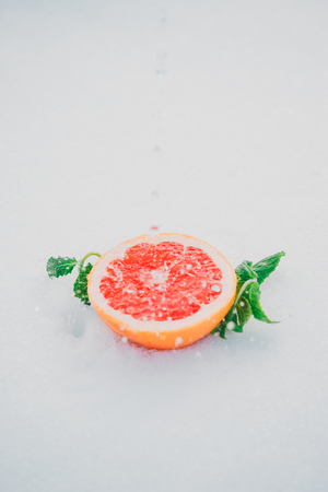 Fresh grapefruit with mint leaves under a rainの写真素材