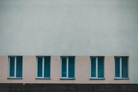 Old Wall with many White Windows with blue curtains