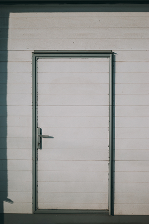 White wooden door with shadow frame in hard lightの写真素材