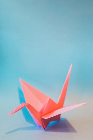 Colorful Origami birds flying to the light. on blue backgroundの写真素材